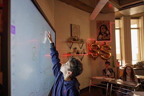 A student solving a math problem. Links to Gifts That Pay You Income